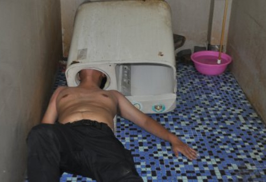 Ein Chinese bleibt mit dem Kopf in der Waschmaschine hängen