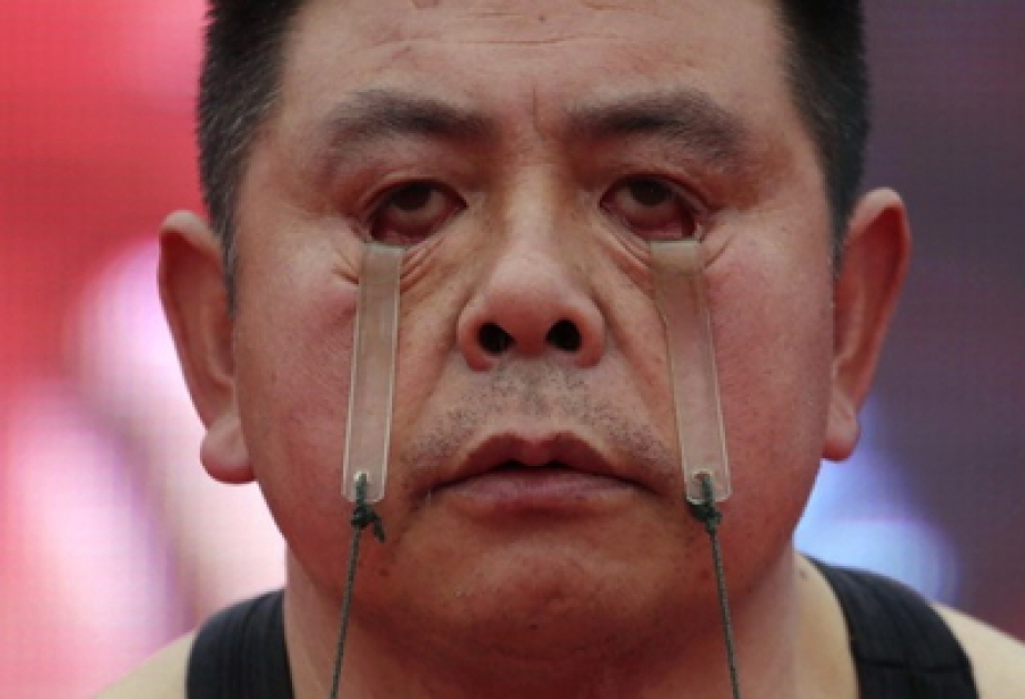 Chinese trägt Wassereimer mit seinen Augenlidern