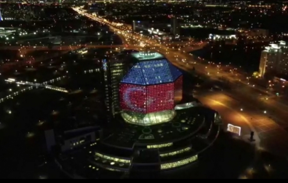 Gebäude der Nationalbibliothek in Minsk für Aserbaidschan in Lichtstrahlen Blau, Rot, Grün beleuchtet VIDEO